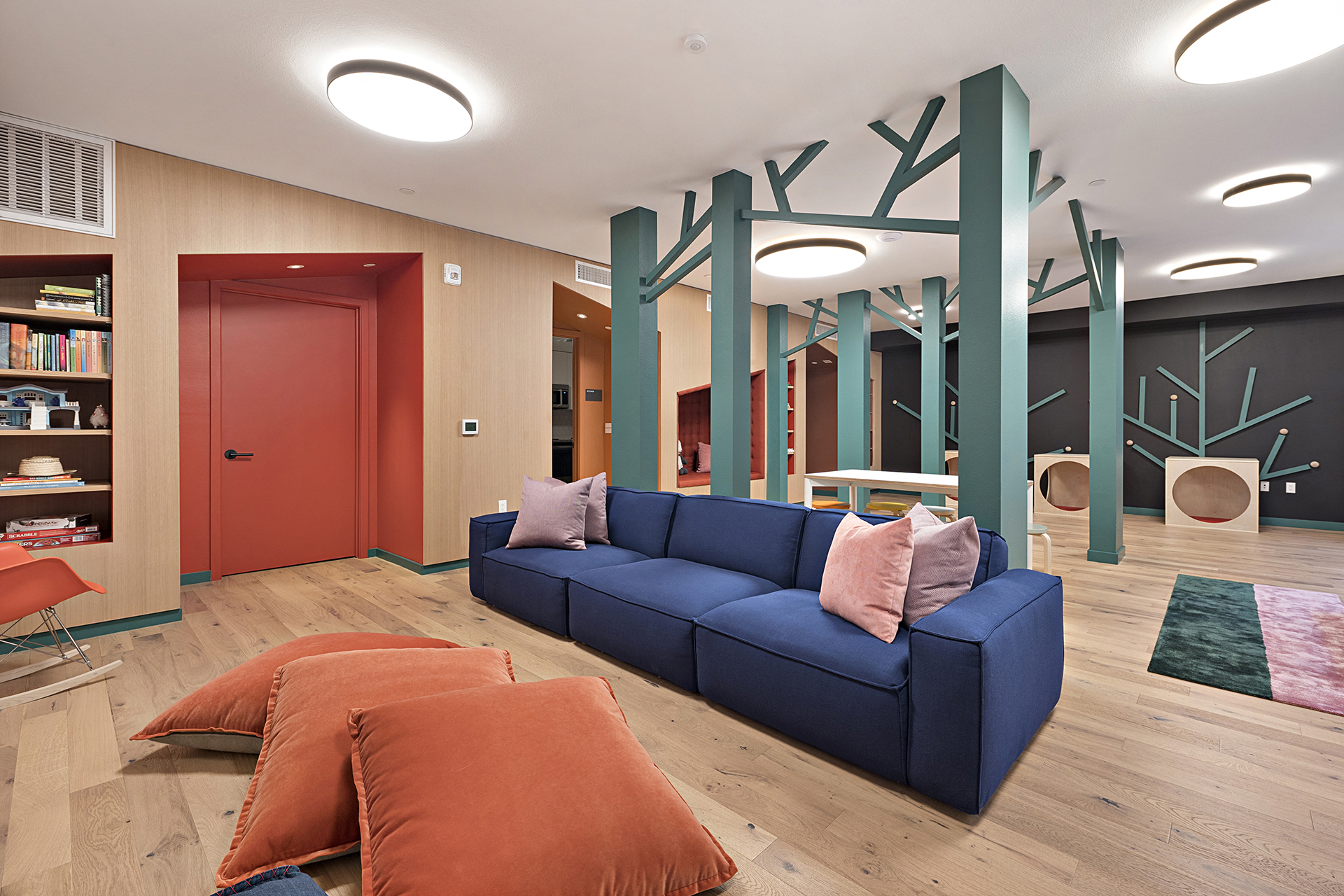 a living room with a blue couch and orange pillows