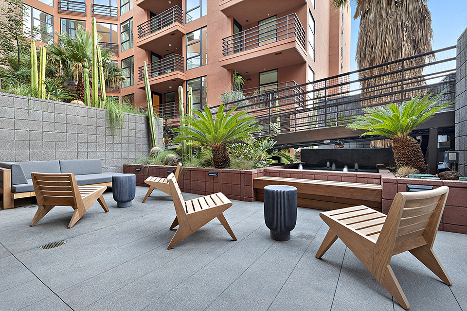 a seating area with chairs and a fire pit in a courtyard