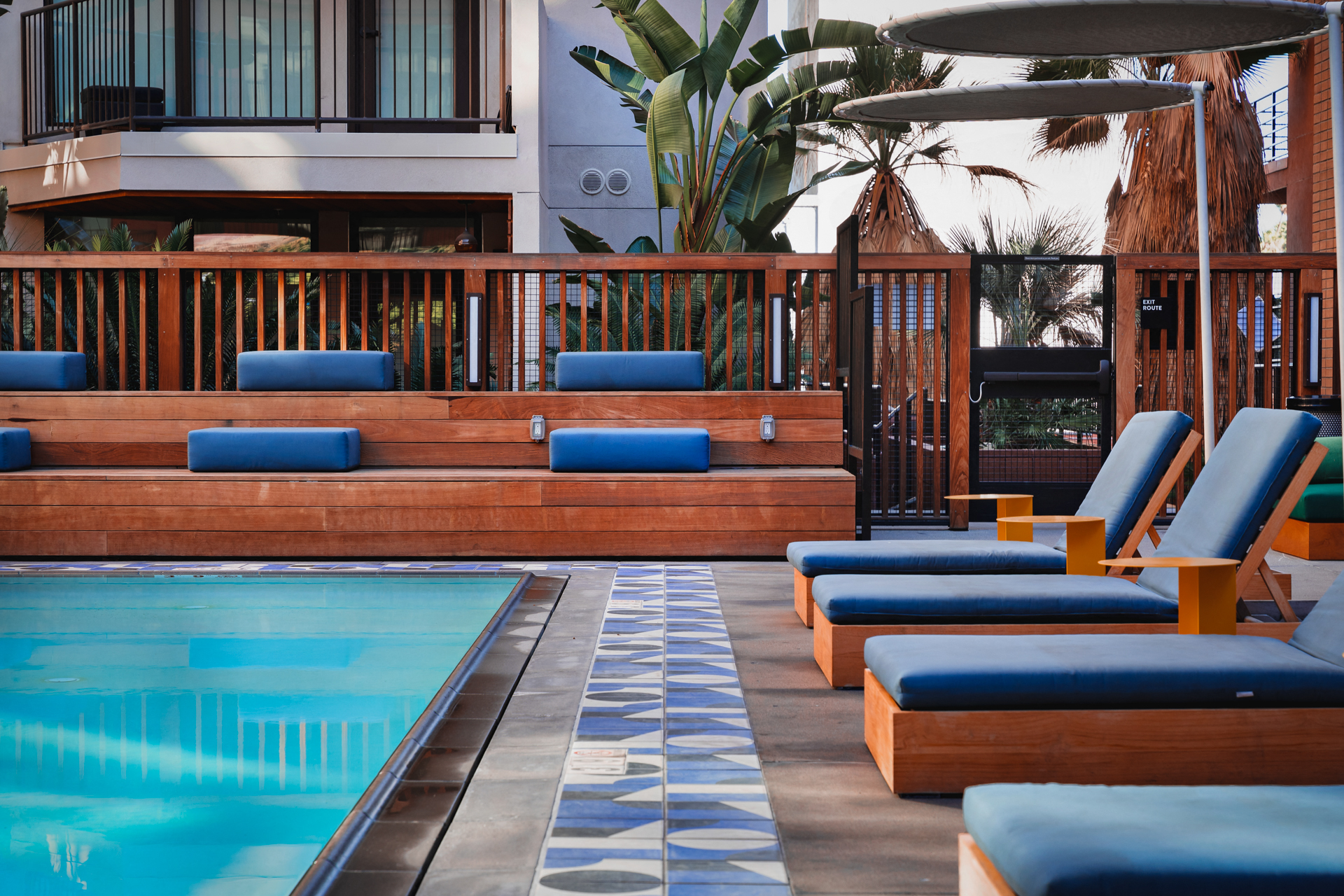 a pool at a hotel with blue lounge chairs