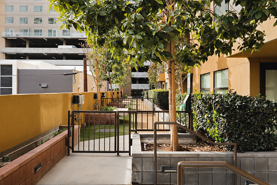 a courtyard with trees and a fence in front of a building