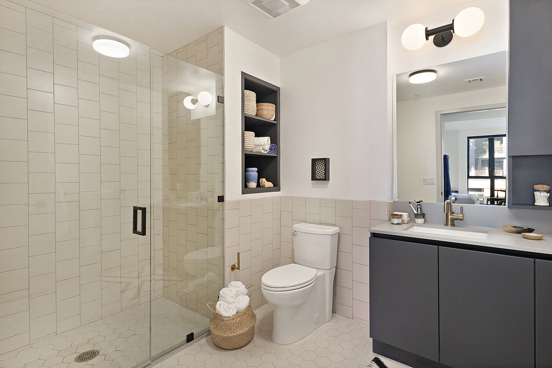 a white tiled bathroom with a shower and a toilet