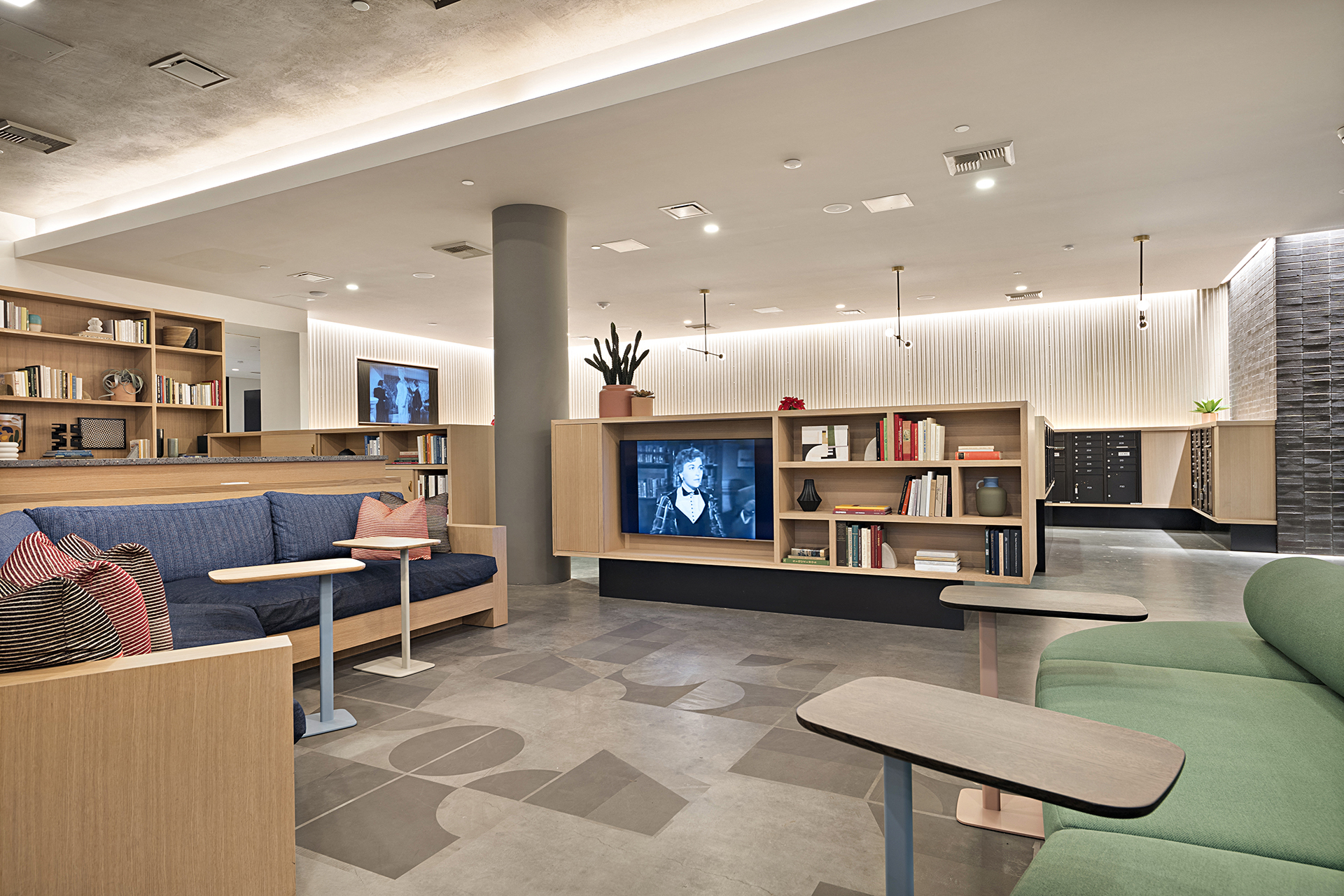 a lobby with couches and tables and a tv