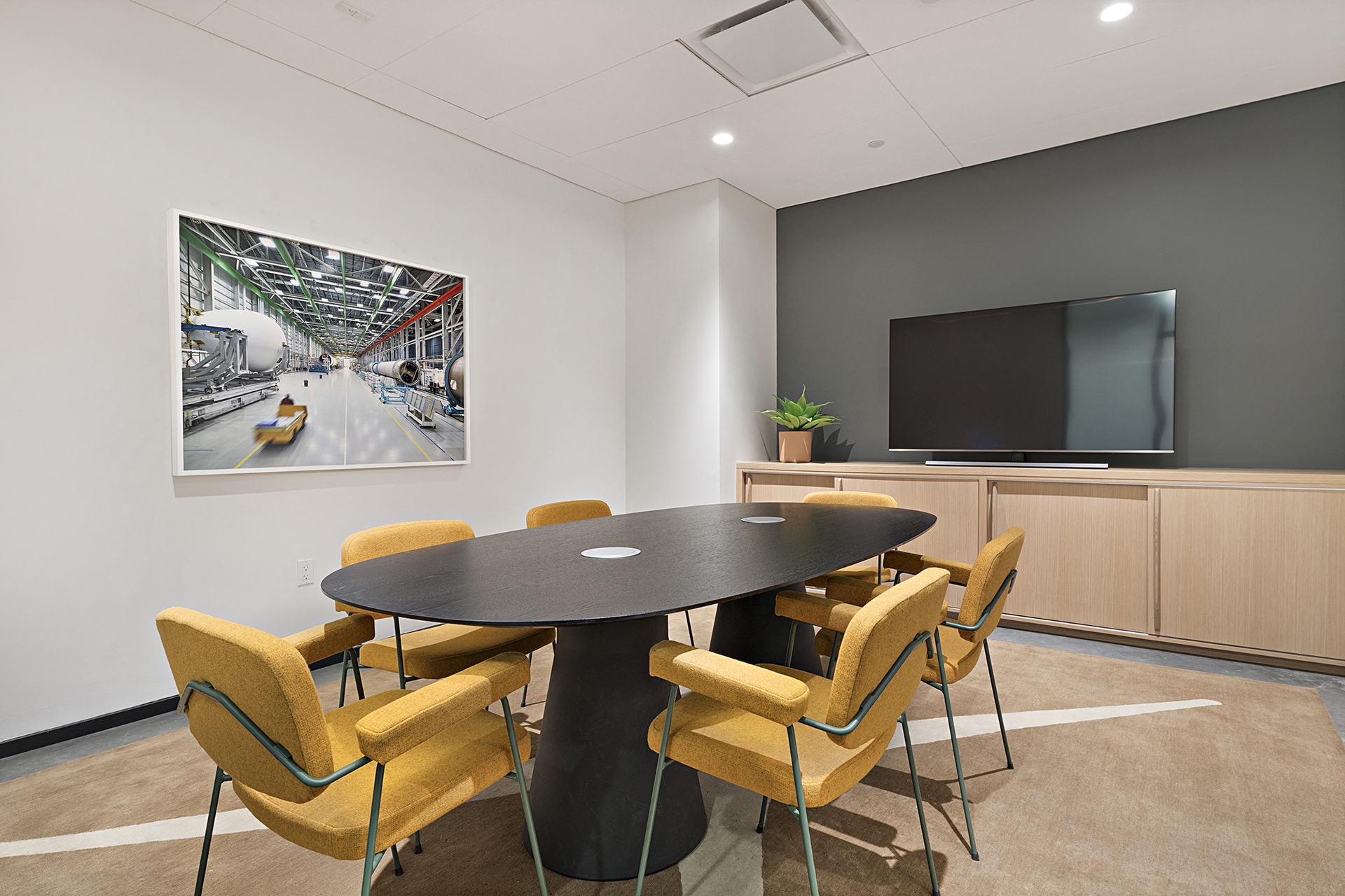 a conference room with a table and chairs and a television