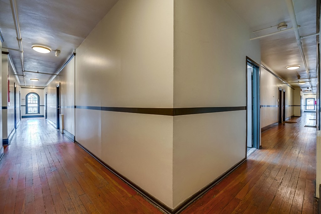 a hallway with wood floors and white walls and doors