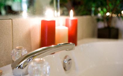 a bathroom sink with three candles on it