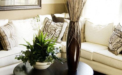 a living room with a couch and a table with a vase