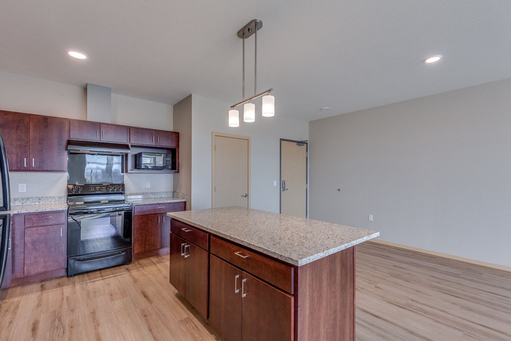 an empty kitchen with wooden cabinets and a marble counter top