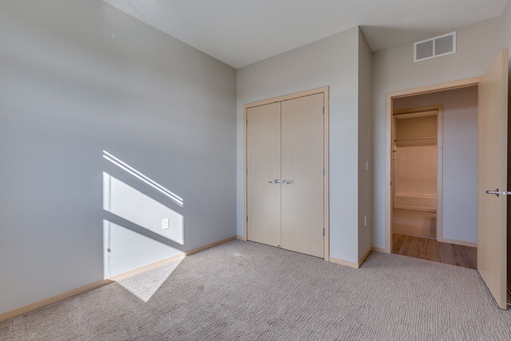 a bedroom with a closet and a door to a bathroom