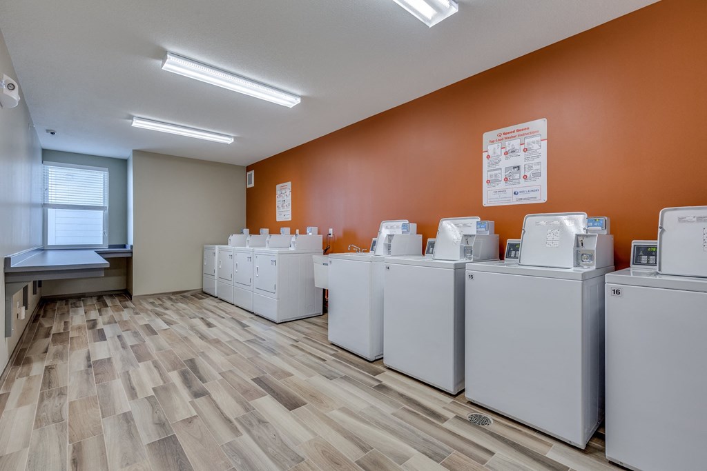 a bunch of washers and dryers in a room
