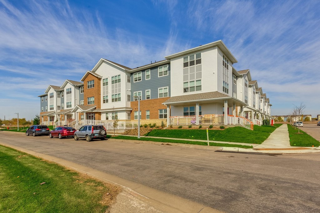 a row of apartment buildings on the side of a street