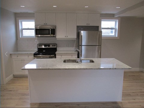 A kitchen with a white countertop and stainless steel appliances.