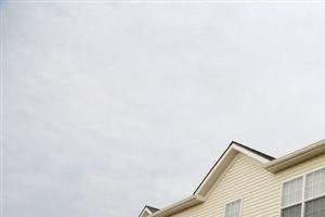 a row of houses on a hill with grass