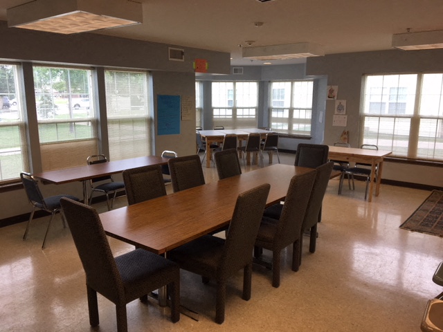 a dining room with tables and chairs and windows