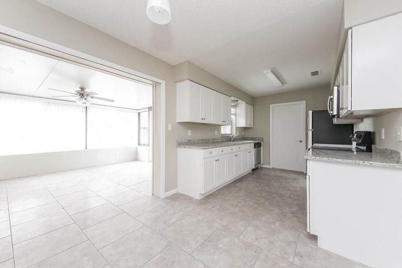 an empty kitchen and living room with a large window