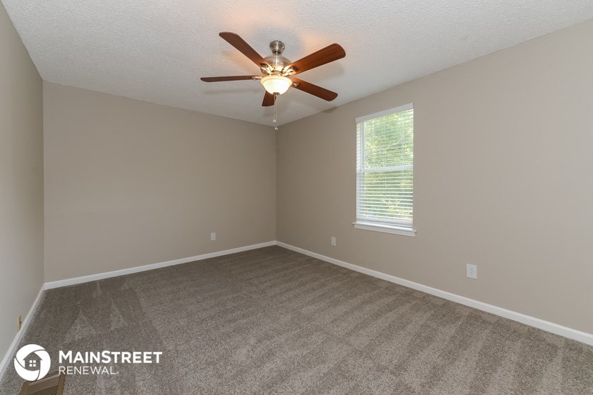 the living room of an empty house with a ceiling fan