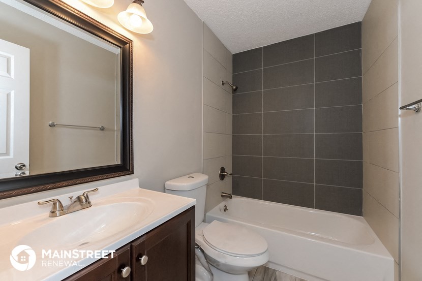 a bathroom with a sink toilet and tub and a mirror