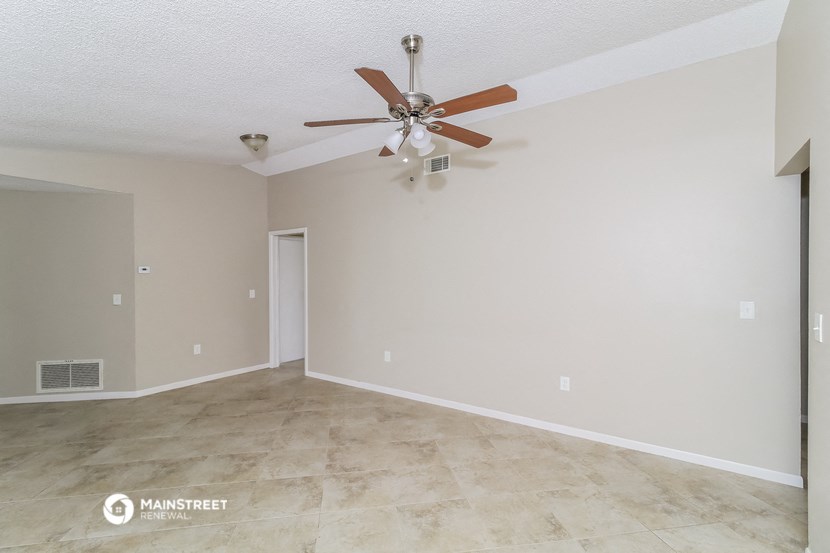 the living room and dining room with a ceiling fan