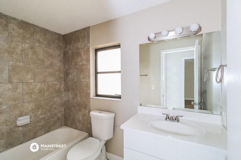 a bathroom with a sink toilet and a mirror