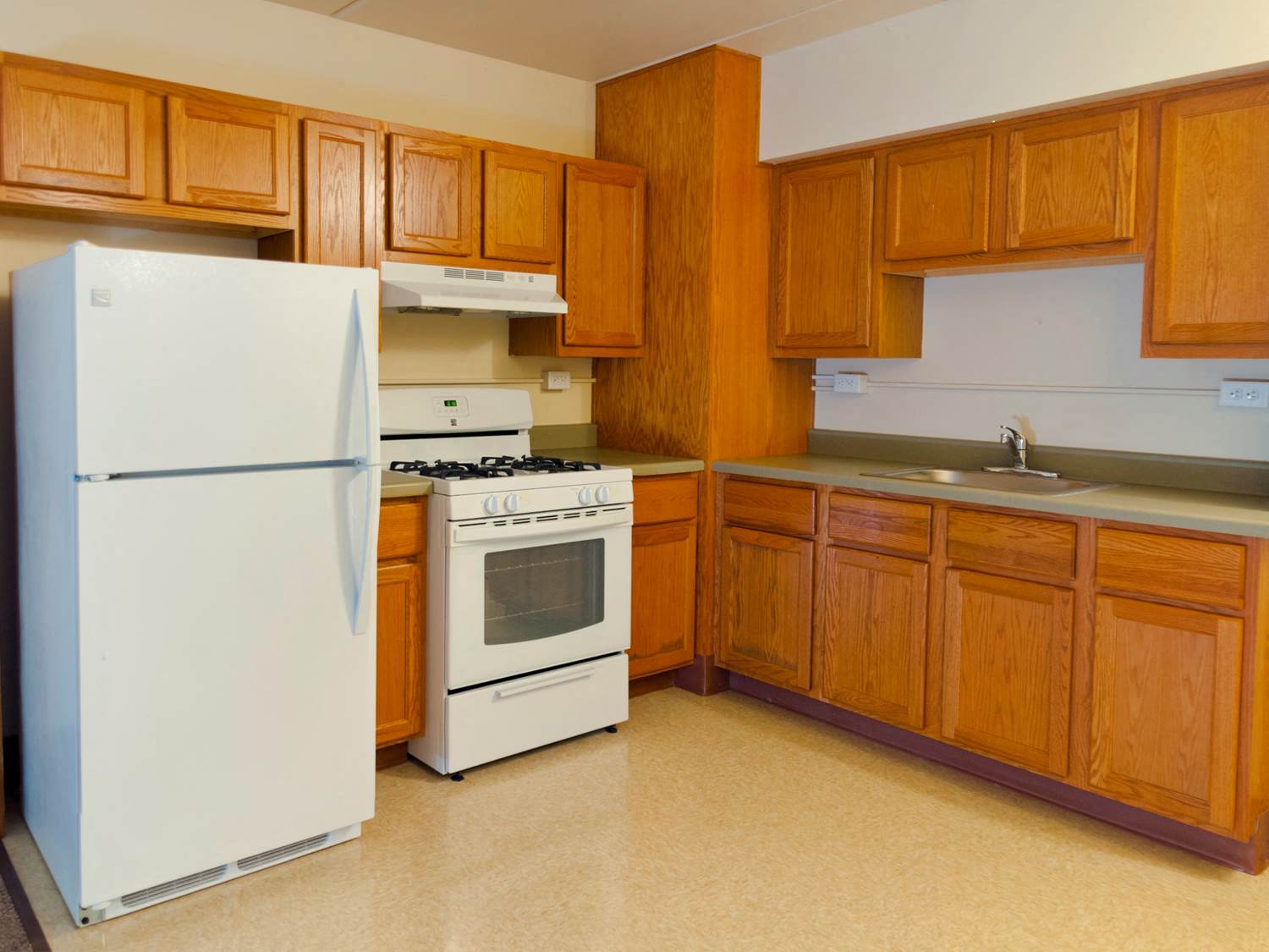a kitchen with white appliances and wooden cabinets