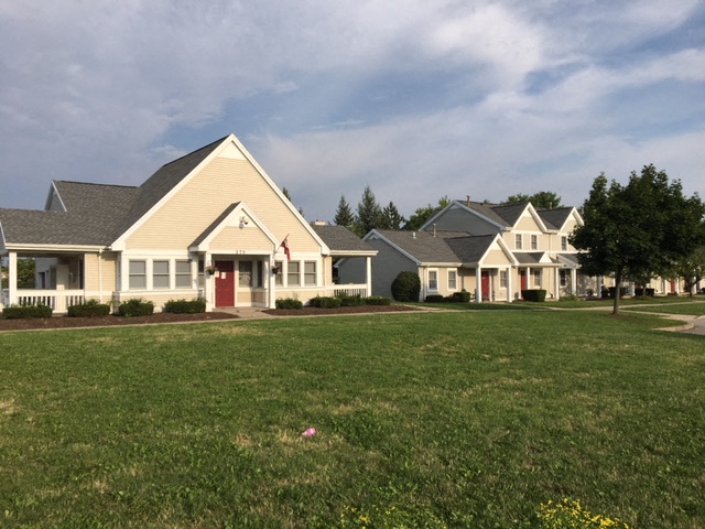 a row of houses in front of a green field