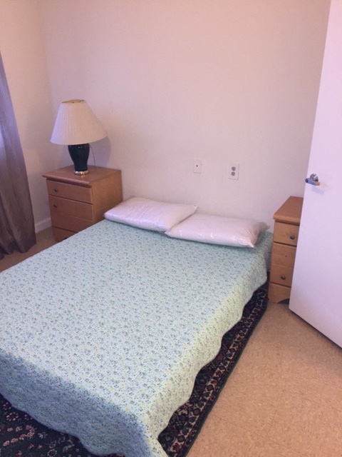 a small bedroom with a bed and a lamp