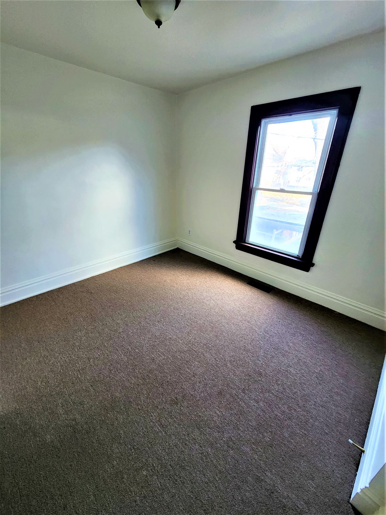 a white room with a window and a carpet