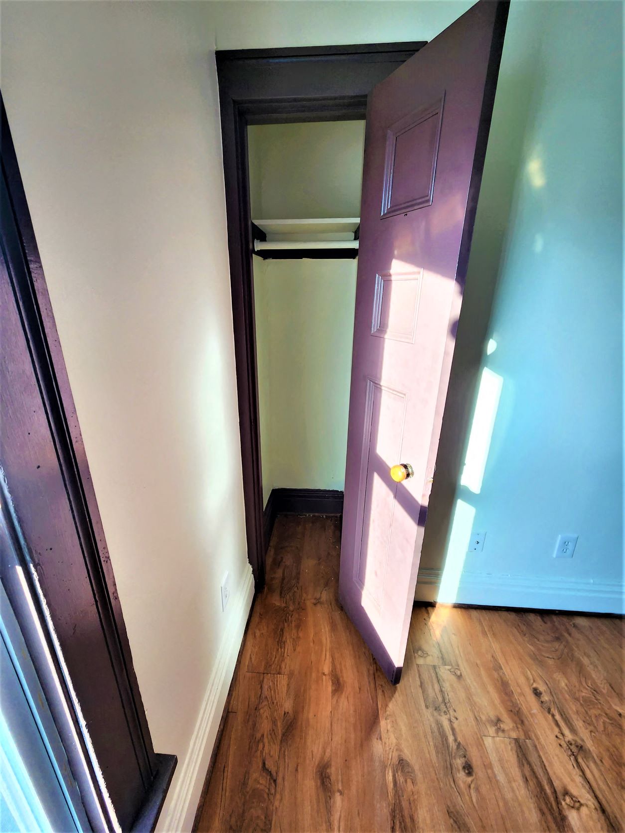 a purple door in a room with wood floors