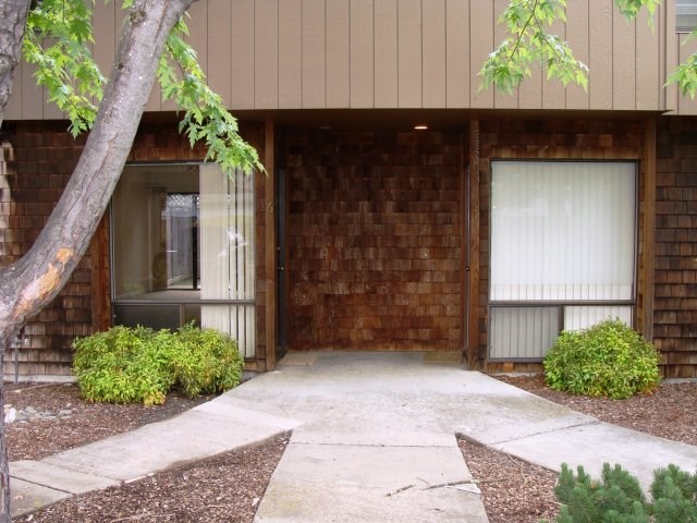 a walkway in front of a building with two garage doors