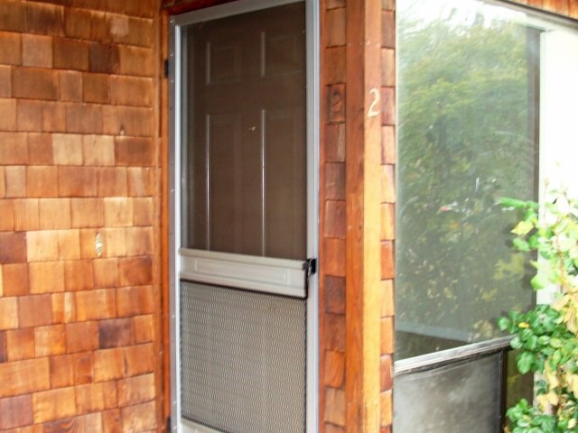 a door to a brick house with a screen door