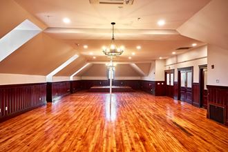 a large room with a wooden floor and a chandelier