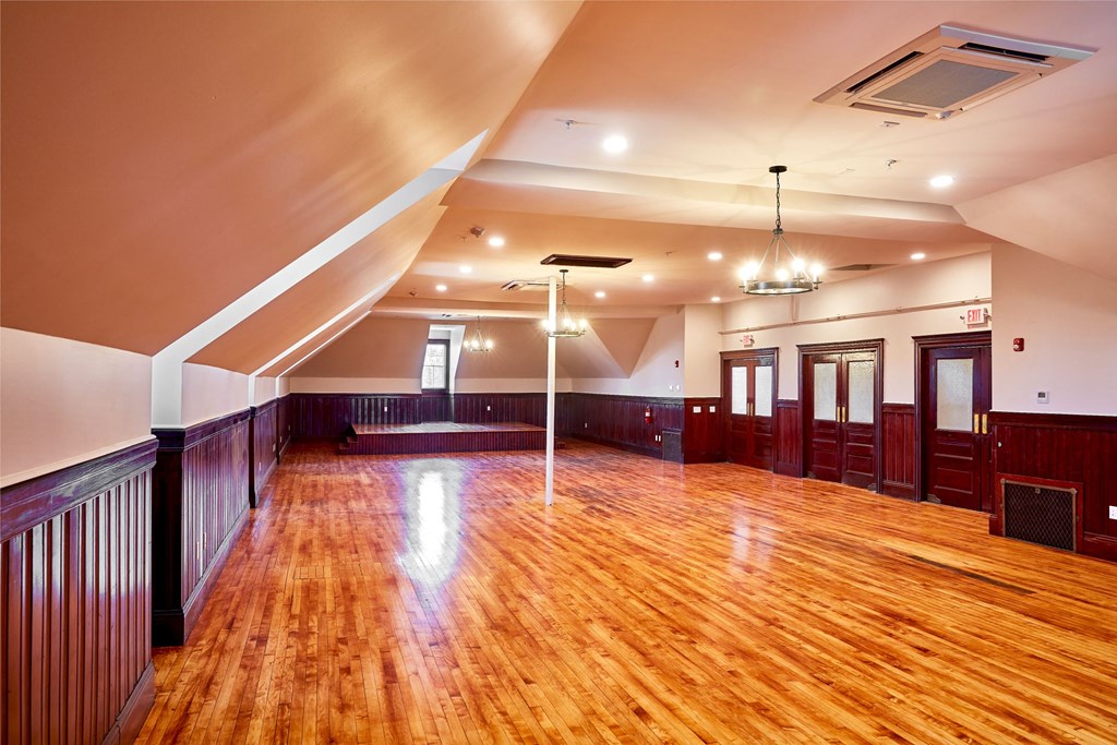 a large empty room with a wood floor and a ceiling