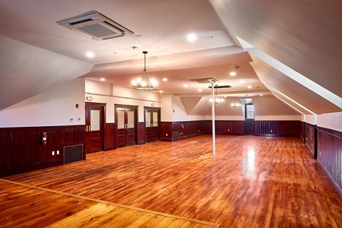 a large room with a wooden floor and a racquetball court