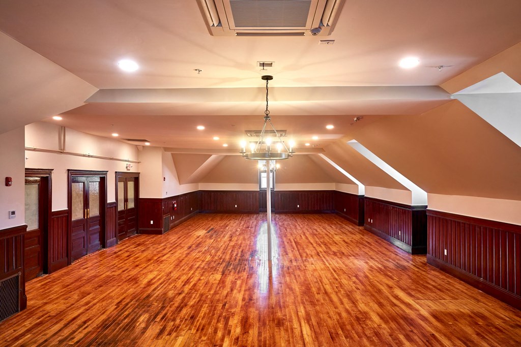 a empty room with a wooden floor and a chandelier