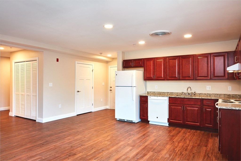 a kitchen with wood floors and a white refrigerator