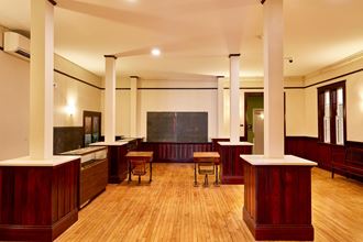 a classroom with wooden tables and a blackboard in the center of the room