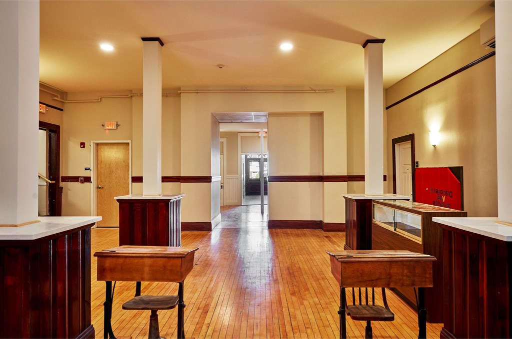 a room with wooden tables and desks and a wood floor