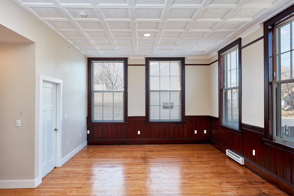 an empty room with wood floors and windows