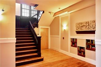 a living room with a staircase and a wooden floor