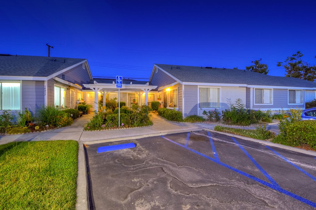 a parking lot in front of some houses at night