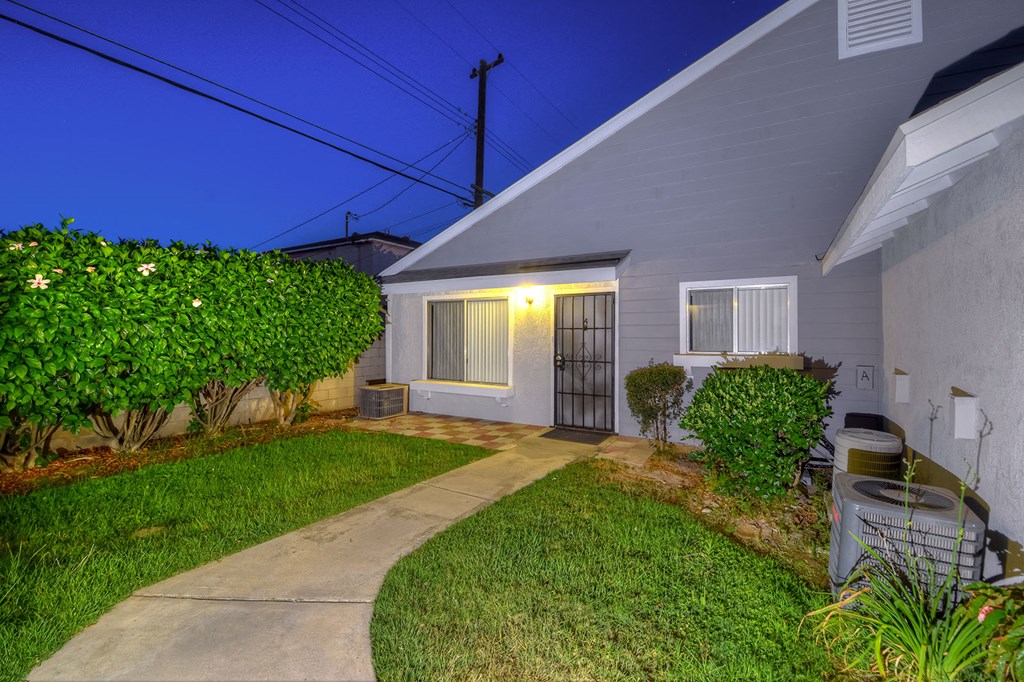a side view of a house with a yard and a sidewalk