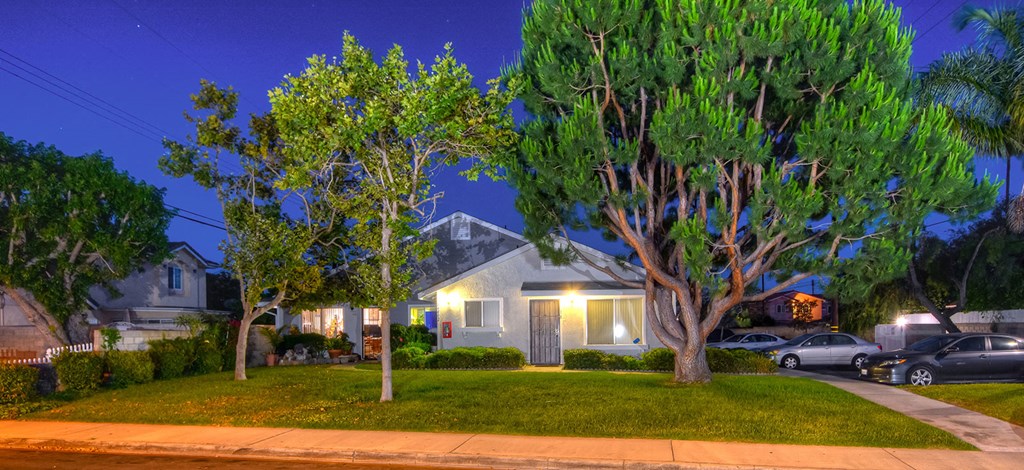 a house with trees in front of it at night