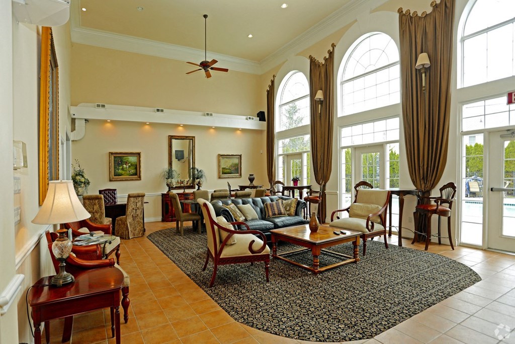 a living room filled with furniture and large windows