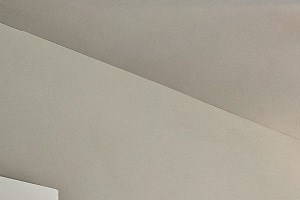 A bedroom with a bed, chair, and ceiling fan.