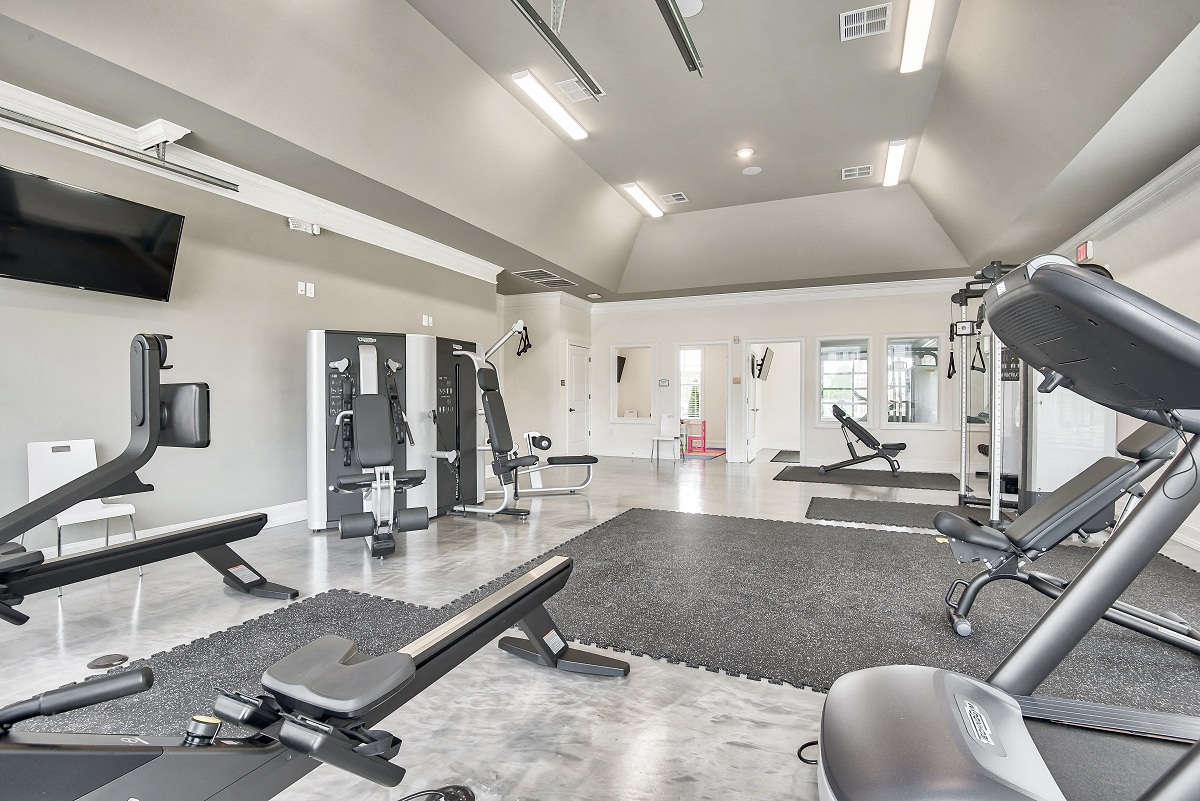 a gym with exercise equipment and a tv on the wall