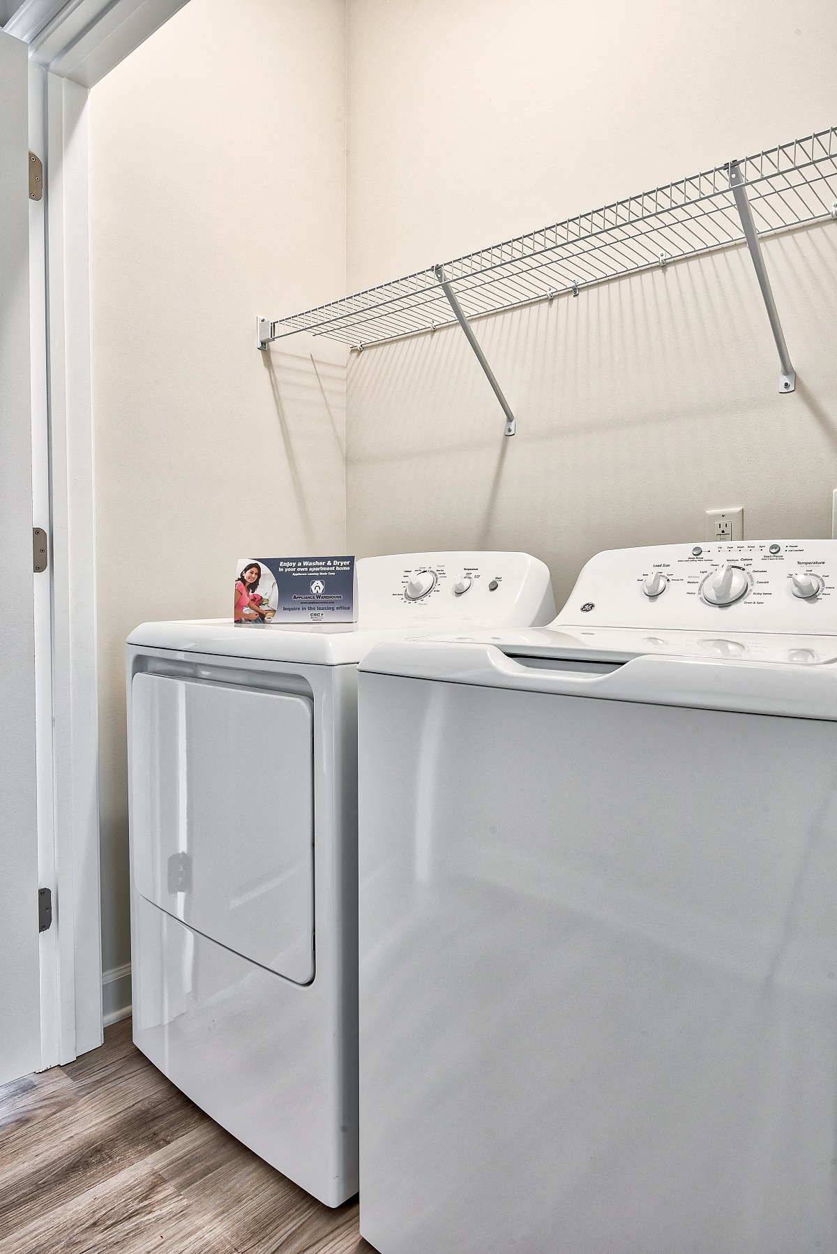 a washer and dryer in a laundry room with a rack on the wall