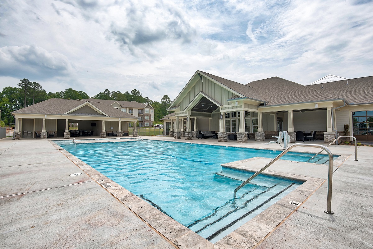 a swimming pool with a house in the background