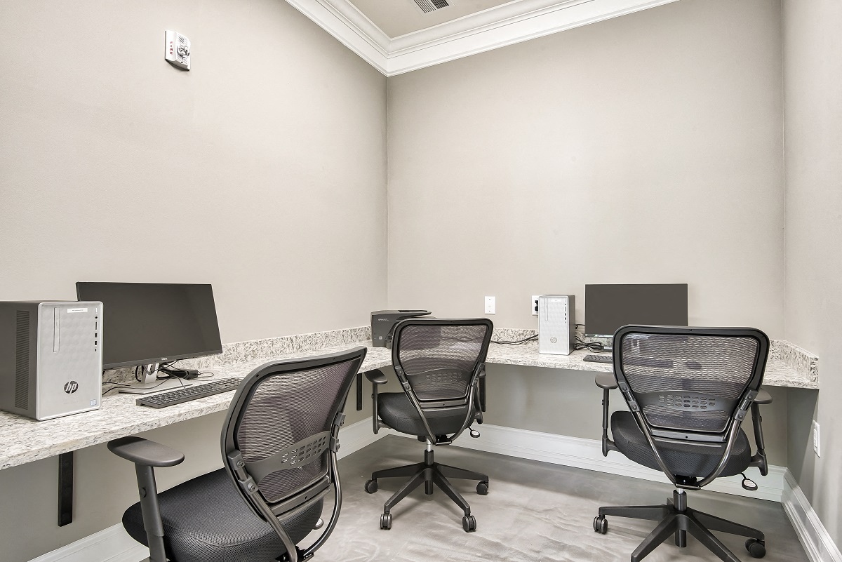 two desks with computers and chairs in a room