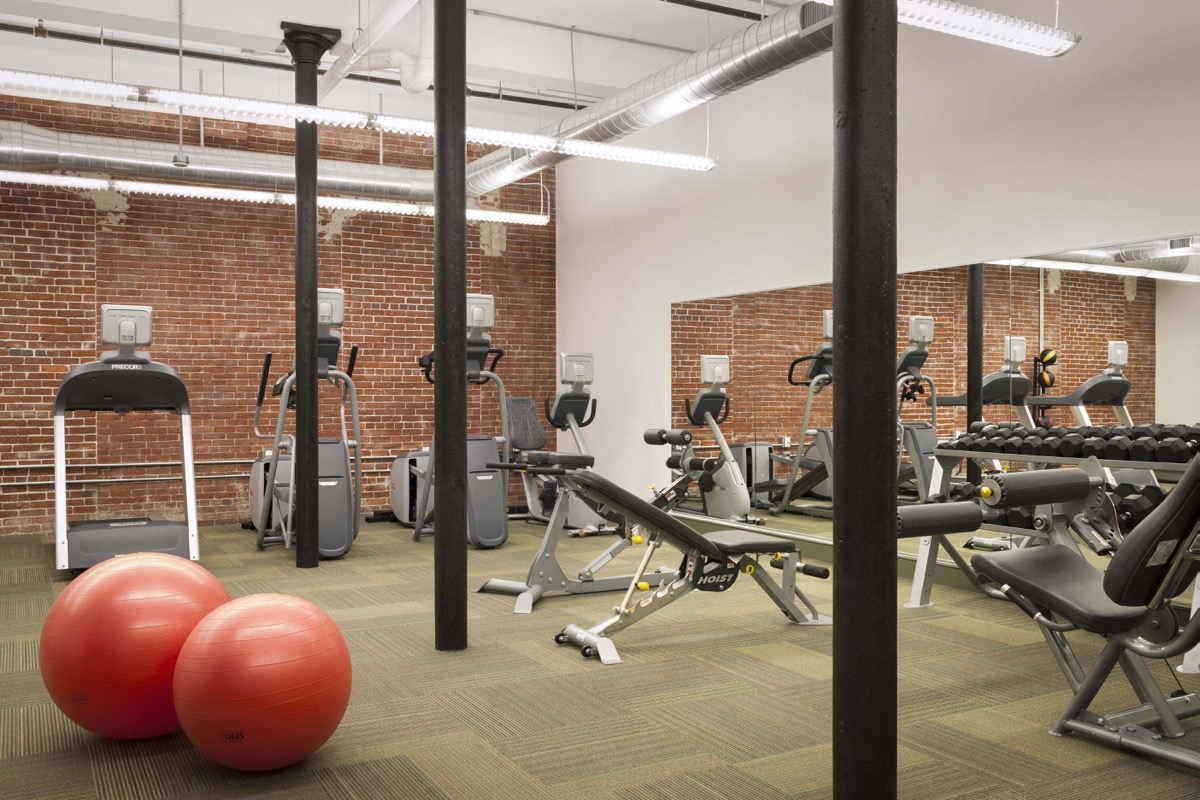 A gym with a variety of equipment including weights and exercise balls.