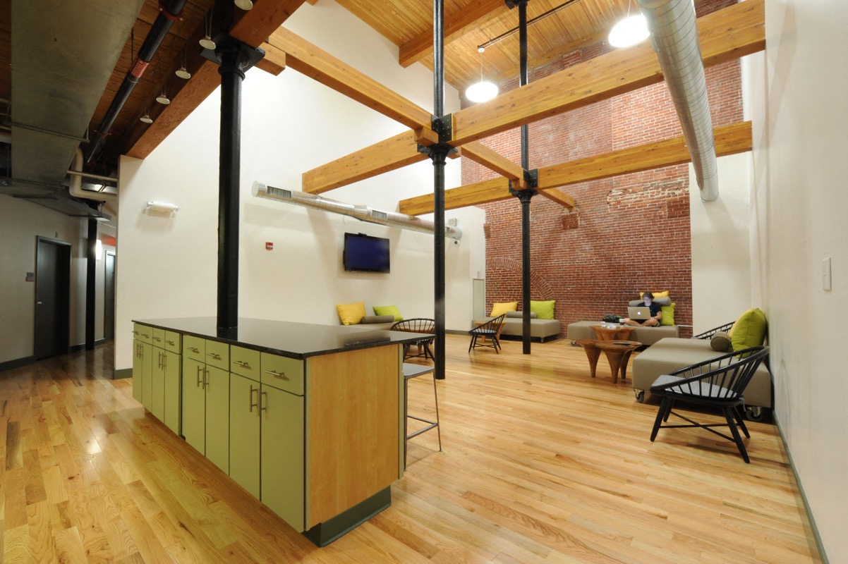 A kitchen with wooden floors and a green island.