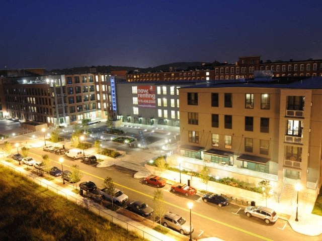 A parking lot is lit up at night in front of a building with a sign that says "how to open a marijuana dispensary.".